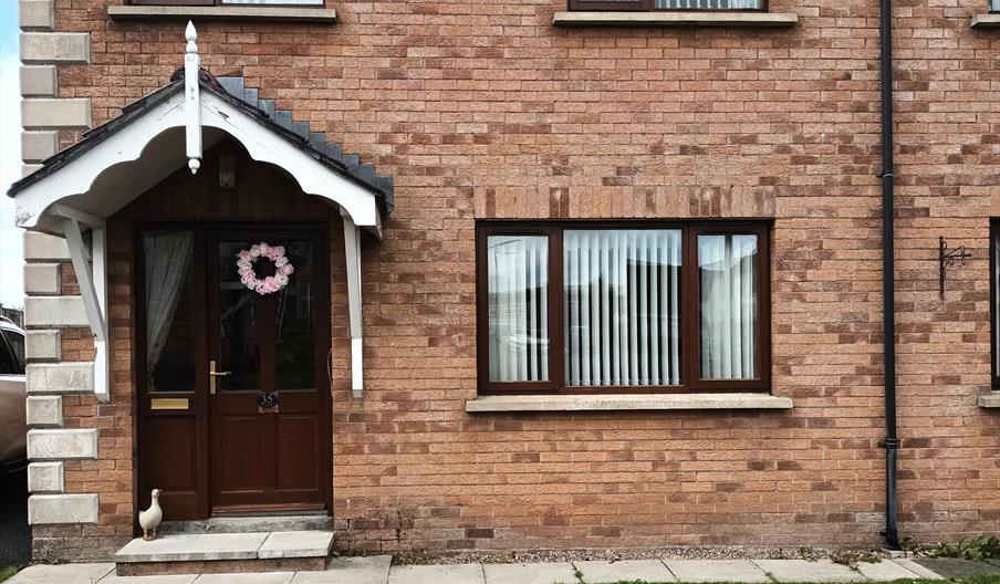 Front exterior of a semi-detached house with a small front lawn.