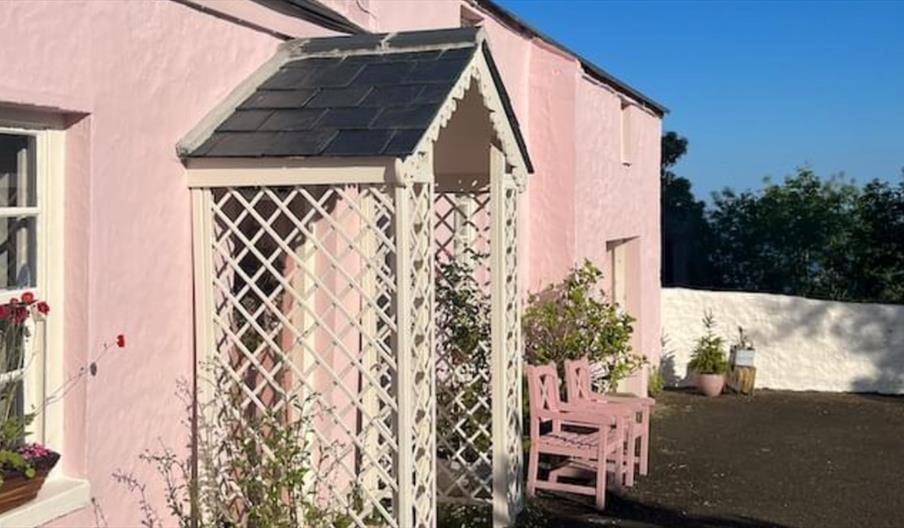 Outside view of the pink cottage with trellis porch