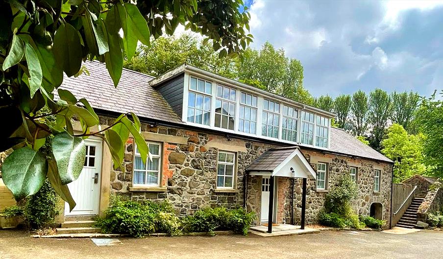 A renovated stone cottage with second floor windows.