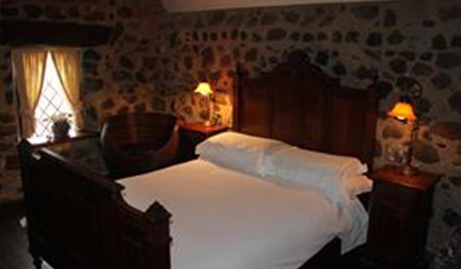 Image shows double bedroom with side tables and lamps