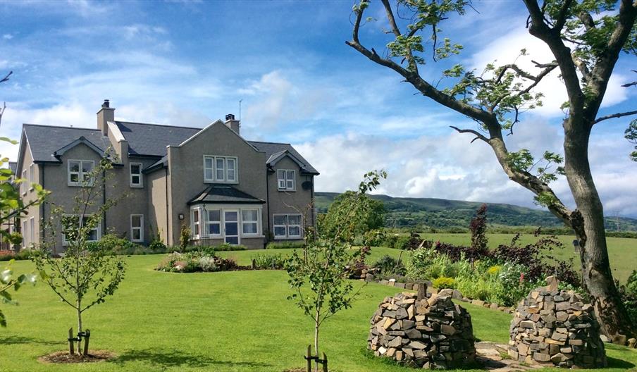 View of BallyCairn House from front garden. Situated on an elevated, picturesque location overlooking the Irish Sea with backdrop views of the Antrim