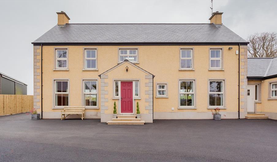 Front exterior of a large two-story lodge.
