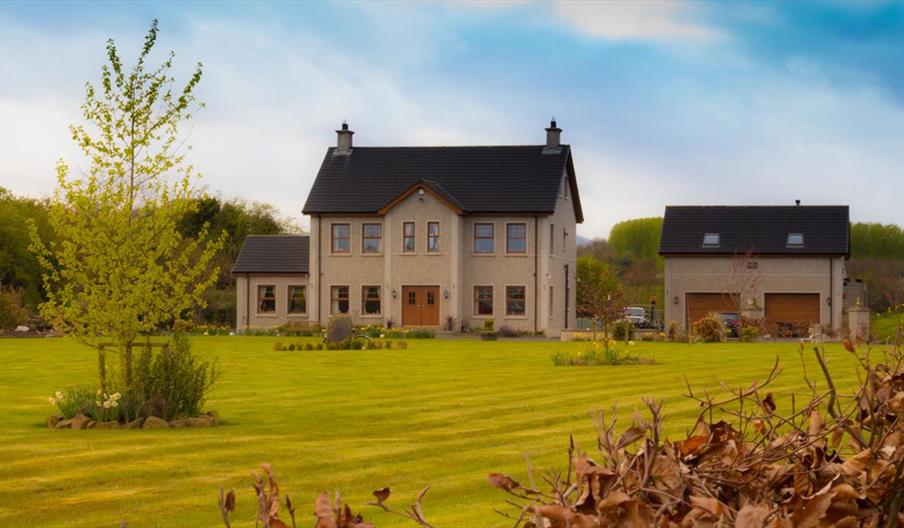 Outside view of 2 storey house with double garage and large garden