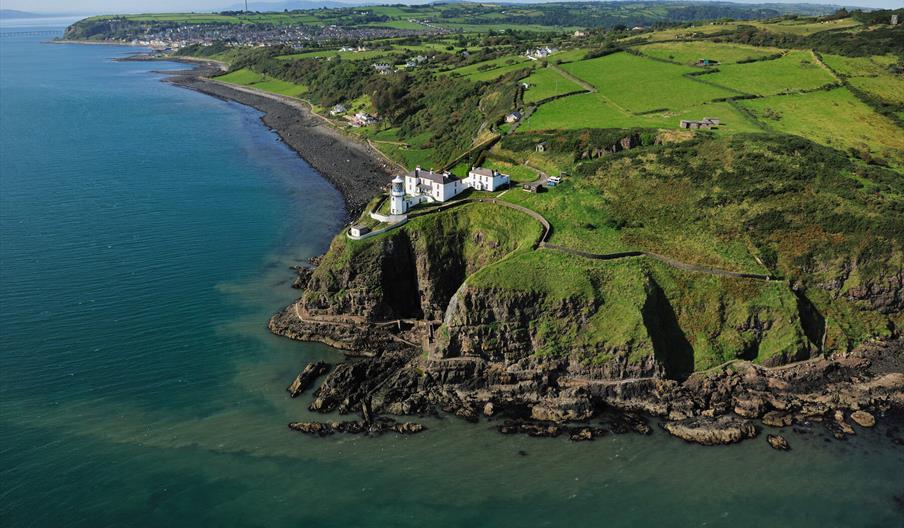 Aerial view of Blackhead Coastal Path and Lighthouse with surrounding countryside