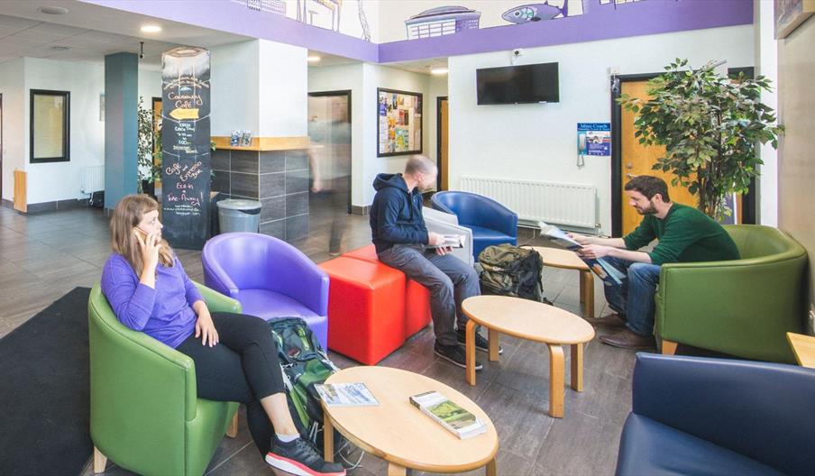 A photo of a communal lobby area with a group of people sitting together.