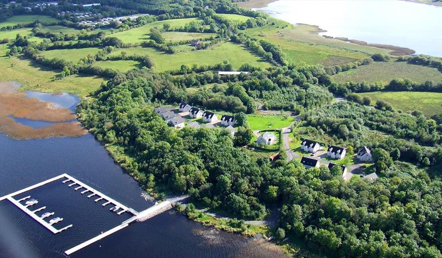 Aerial site photograph of green site with marina in lake