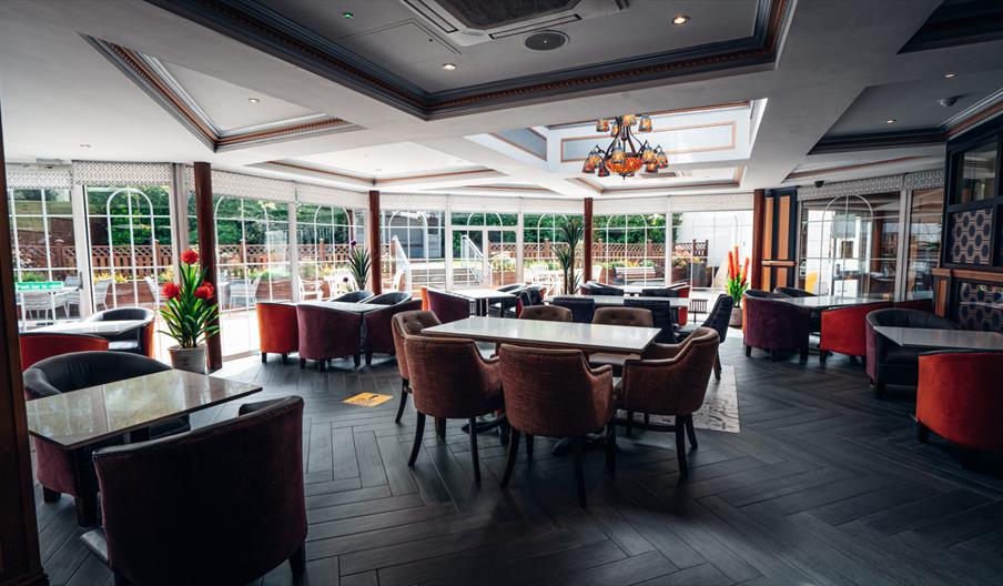 An image showing a dining room with a window wall out to an outside dining area.
