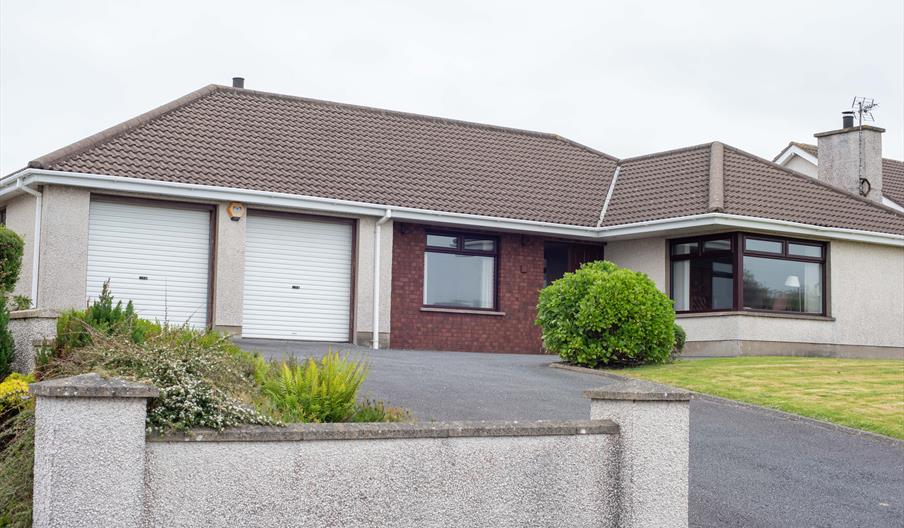Exterior of Warren Crescent, single-storey self-catering accommodation with attached garage, driveway and front lawn.