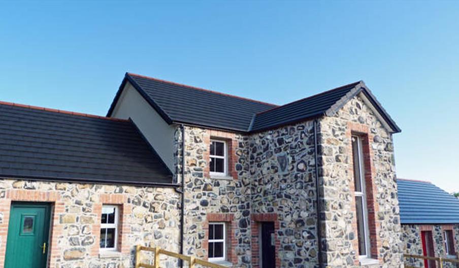 Front exterior view of stone cottages.