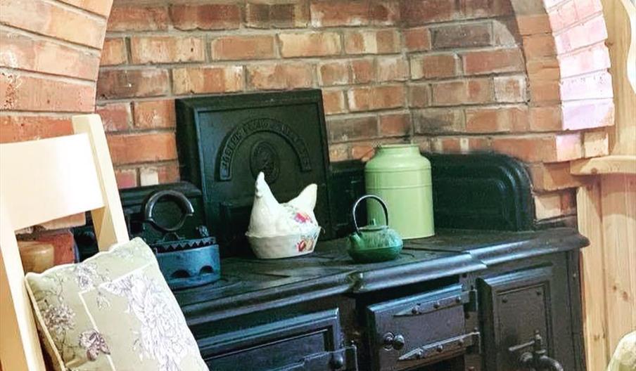 Image shows Aga in kitchen area with explosed brickwork surrounding it