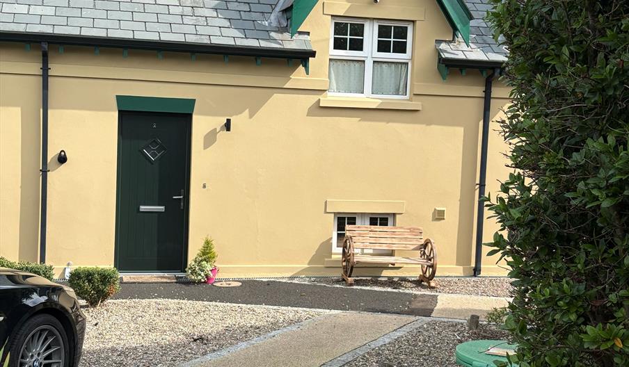 Photograph of front of The Distillers View, bench and plant