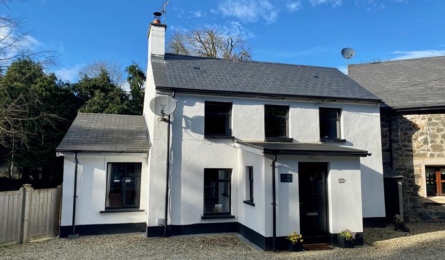 Photo of front of cottage showing position next to the attached old mill