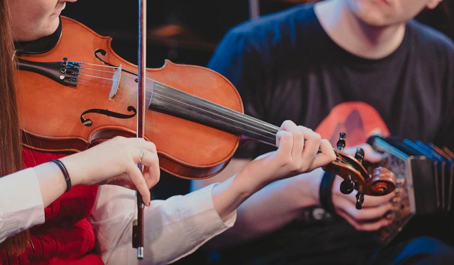Two people playing traditional musical instruments