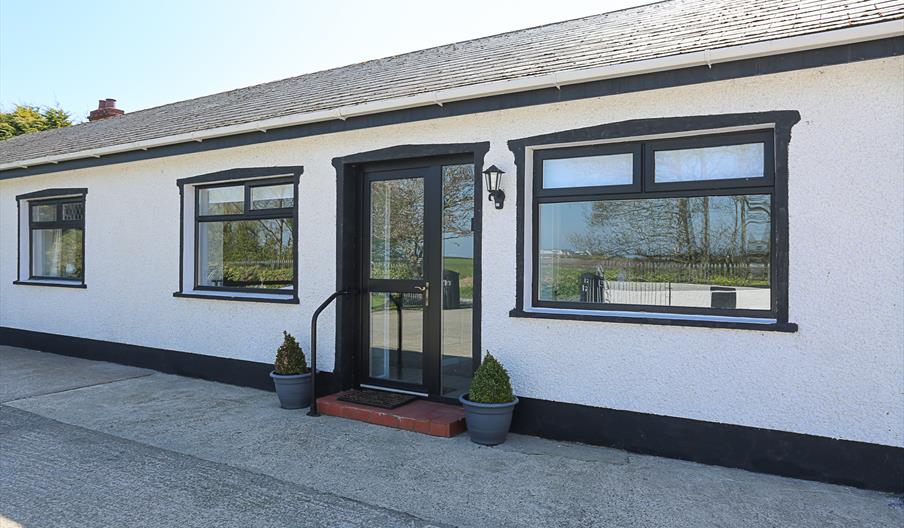 View of the front of the building, a hand rail is provided for ease of access via the step.