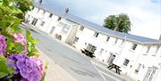 Image shows row of white cottages with picnic tables outside each cottage