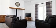 Kribben Cottages - Crannoge Cottage sitting area with fire place and tv