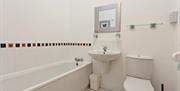 Photo of white bathroom with bath
