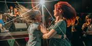 Two women céilí dancing.