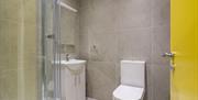 A tiled bathroom with a shower, sink and toilet.