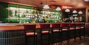 Stylish hotel bar with red leather seating, illuminated shelving and a modern Irish pub atmosphere.