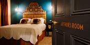 Picture of Arthur's suite inside Arthur's Guesthouse with carefully made double bed and side lamps on the walls