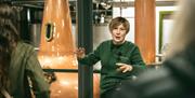 A tour guide standing in front of the whiskey stills.