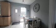 Kitchen table for 4 people. Massive clock on wall. Back door out to small patio with vintage bistro table and chairs