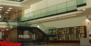 Interior photograph of the PRONI atrium showing two floors and a staircase in the centre of the shot.